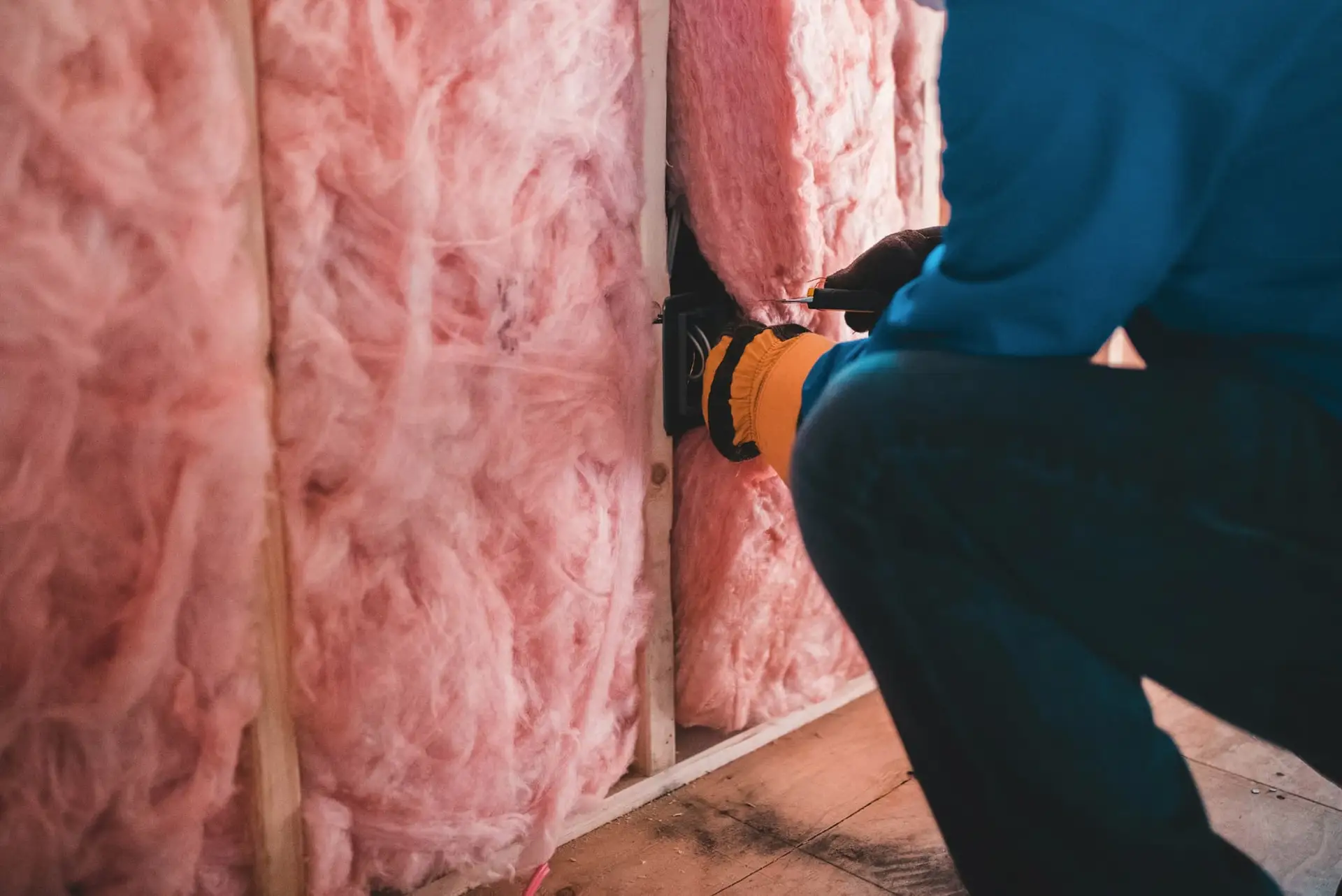 Vakman plaatst minerale wol tussen de stijlen