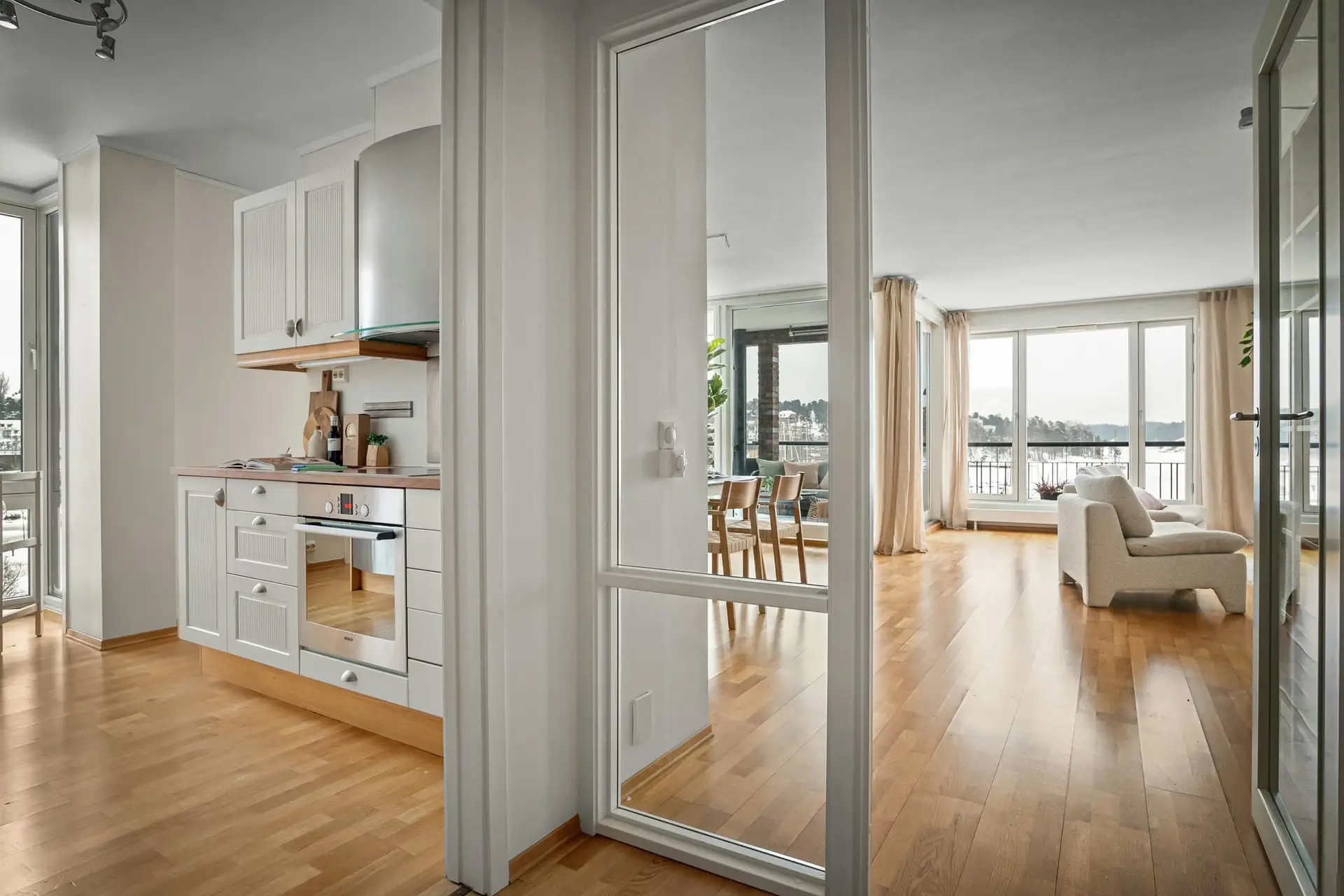 Doorzicht met glazen scheidingswand tussen keuken en woonkamer