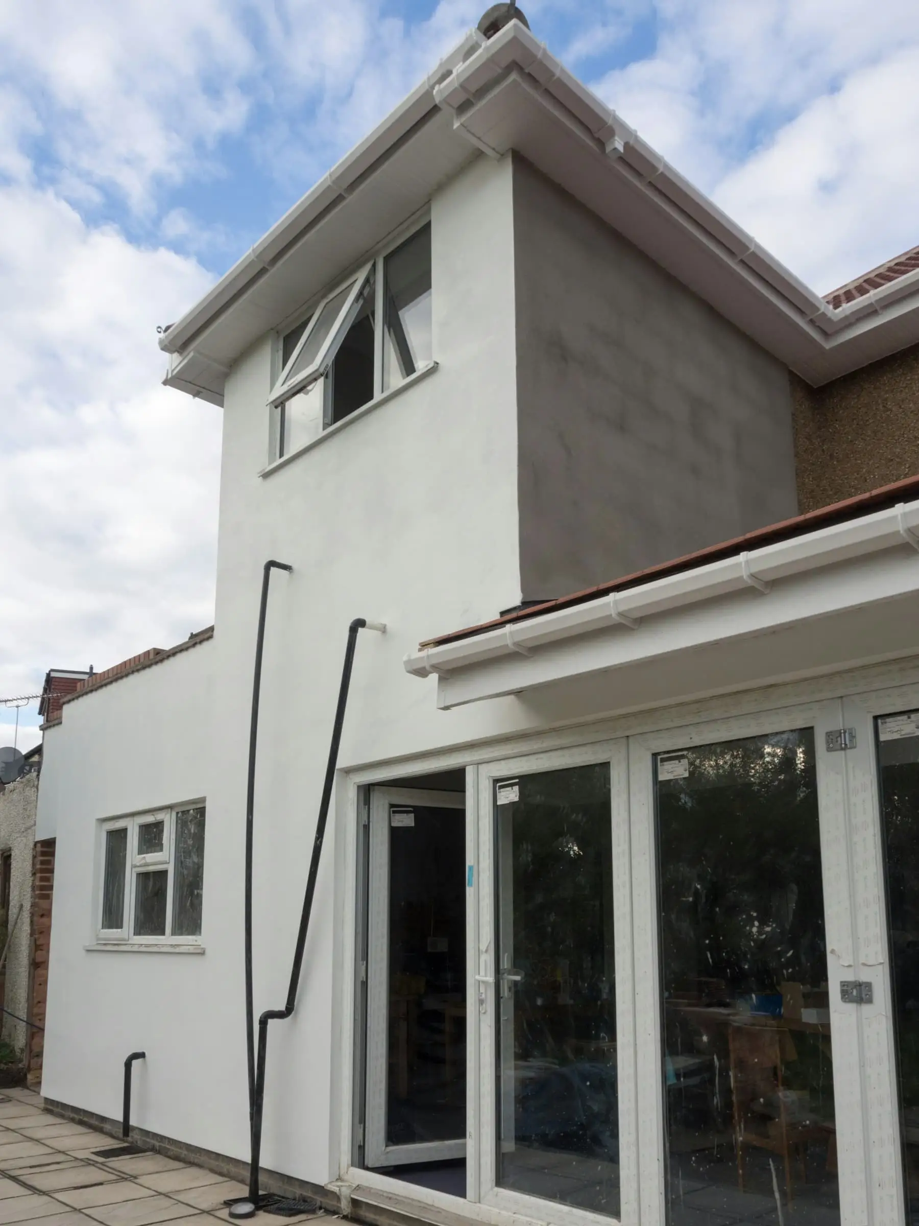 Afgewerkte witte aanbouw met glazen deuren