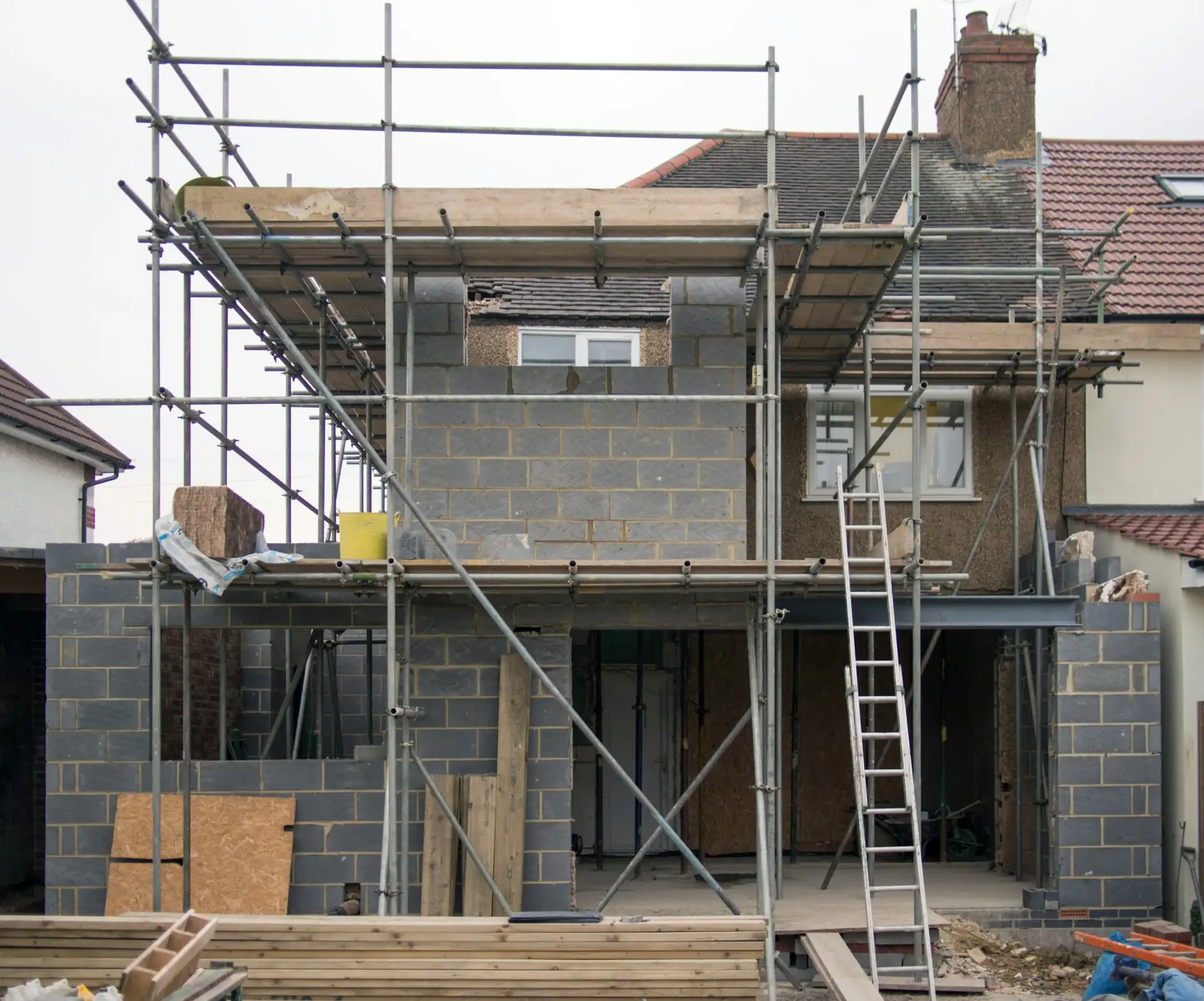 Achtergevel in de stelling, met nieuwe verdieping in snelbouwsteen en ladders