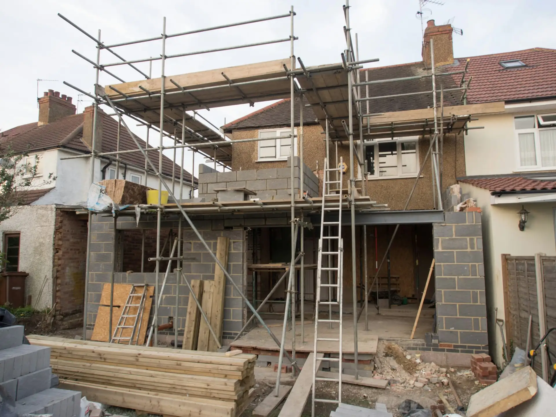 Rijwoning met stelling en nieuwe achterbouw in snelbouwsteen tijdens de ruwbouw