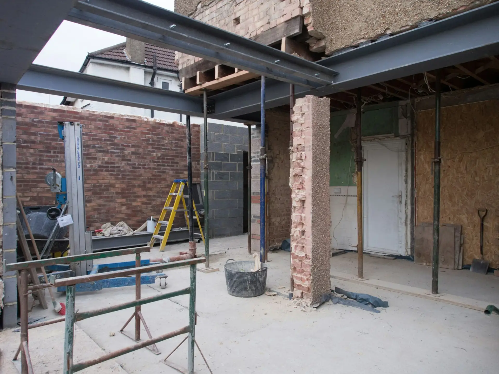 Opengewerkte woning met nieuwe stalen liggers en tijdelijke stutten tijdens een totaalrenovatie