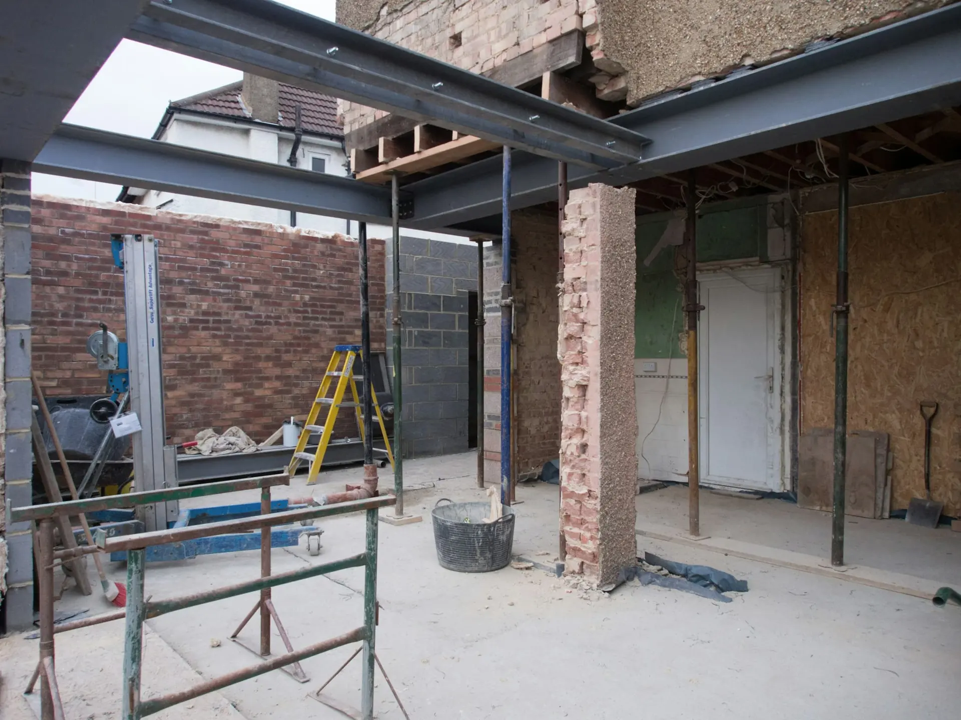 Opengewerkte woning met nieuwe stalen liggers en tijdelijke stutten tijdens een totaalrenovatie