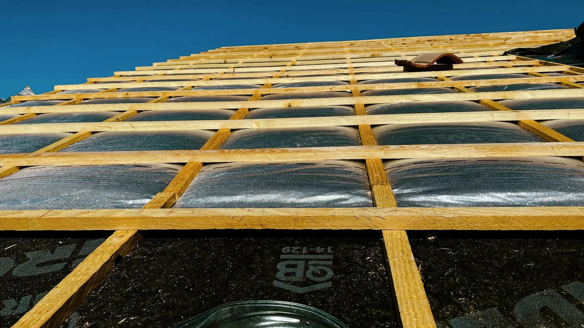 Reflecterende isolatie tussen gele panlatten
