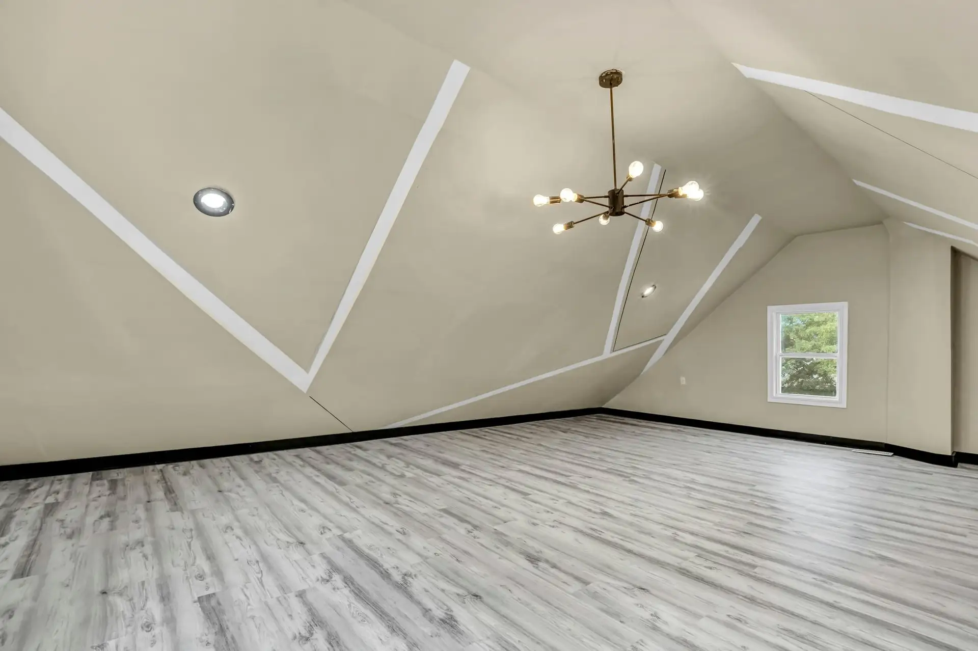 Witte zolder met spots en een klein raam