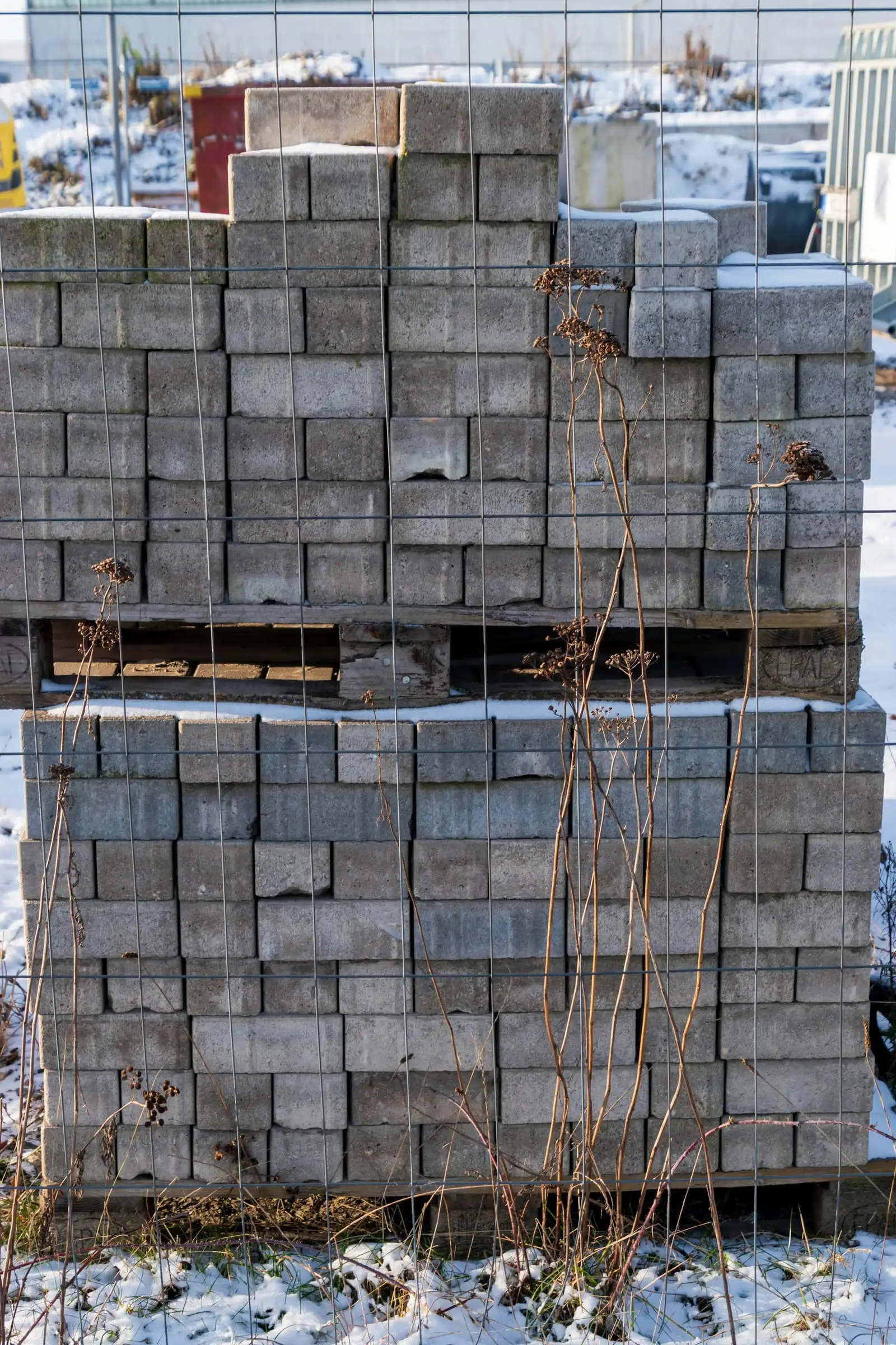 Gestapelde betonblokken op palletten op een werf
