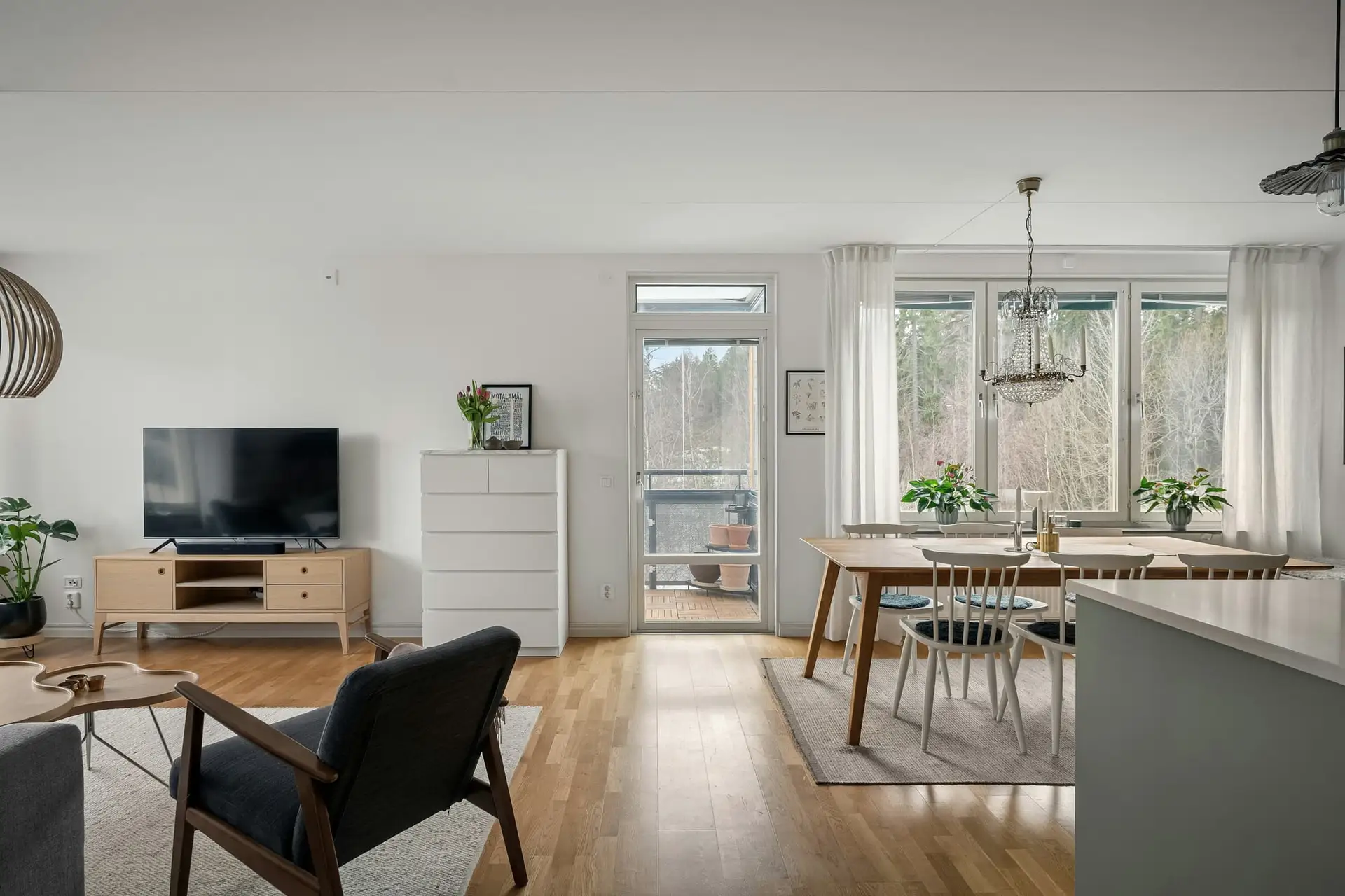 Open leefruimte met zithoek, eettafel en houten vloer
